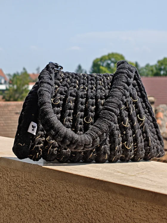 Black crochet bag woven with a fine gold thread and small brass rings